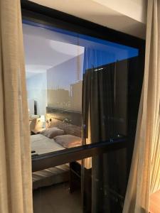 a view of a bedroom with a bed and a window at Flat hotel Athos Bulcão. in Brasilia