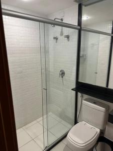 a bathroom with a glass shower and a toilet at Flat hotel Athos Bulcão. in Brasília