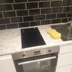 a kitchen counter with a stove and a yellow block at Bakus Executive Suite in Abbey Wood