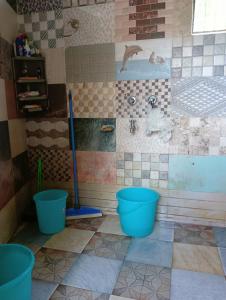 a bathroom with a shower and two blue buckets at Wild Homestay in Baragrān