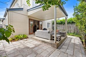 patio trasero con pérgola blanca en Charming 3-Bedroom Townhouse with Private Courtyard en Brisbane