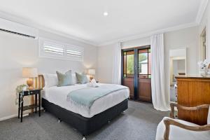 1 dormitorio con cama, escritorio y ventana en Charming 3-Bedroom Townhouse with Private Courtyard en Brisbane