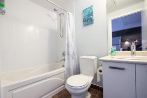 a white bathroom with a toilet and a sink at Lovely 1 bed in Central Toronto in Toronto