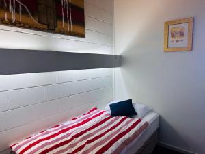 Una habitación con una cama con una almohada a rayas encima. en Fishpen Holiday Units, en Merimbula