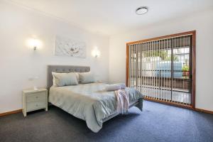 a bedroom with a bed and a large window at Tangerine - Pet Friendly - 3 Mins Walk to Beach in Sanctuary Point