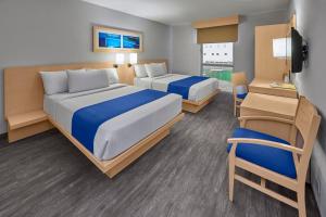 a hotel room with two beds and a chair at City Express by Marriott Puebla Angelopolis in Puebla