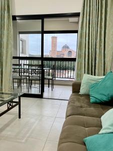 ein Wohnzimmer mit einem Sofa und einem großen Fenster in der Unterkunft Vista Privilegiada 5 minutos da Basílica in Aparecida