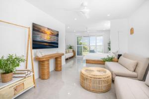 uma sala de estar com um sofá e uma mesa em 1-46 Manooka Drive - Rainbow Beach Aircon. Wifi. Pool. View em Rainbow Beach