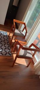 uma cadeira de madeira sentada num quarto ao lado de uma janela em Silver Oak By Exuberance Stays (Independent Holiday Home) em Wayanad