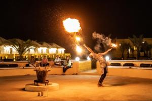 un hombre está haciendo un espectáculo de fuego por la noche en Lakhina Heritage desert camp, en Jaisalmer