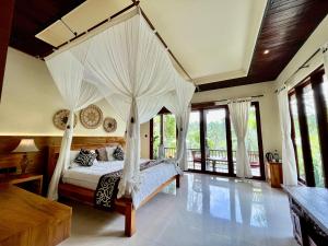 a bedroom with a canopy bed with white curtains at The Papas Villas in Tegalalang +27 photos