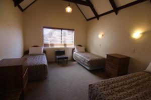1 dormitorio con 2 camas, vestidor y ventana en Apex on Fenton, en Rotorua