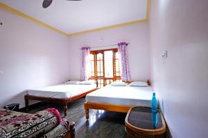 Habitación con 2 camas y ventana en Kodebailu Homestay - 3BH Full Villa, Home Food, Coffee Estate, en Sakleshpur