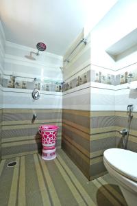 a bathroom with a toilet and a pink bucket at Kodebailu Homestay - 3BH Full Villa, Home Food, Coffee Estate in Sakleshpur