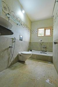 a bathroom with a toilet and a sink and a tub at Kodebailu Homestay - 3BH Full Villa, Home Food, Coffee Estate in Sakleshpur
