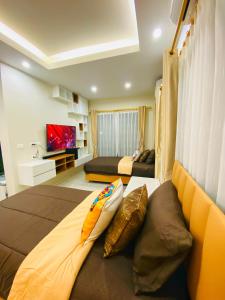 a large bedroom with two beds and a television at Krabi Aonang & Alpha villa in Ao Nam Mao