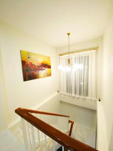 a room with a staircase with a window and a chandelier at Krabi Aonang & Alpha villa in Ao Nam Mao