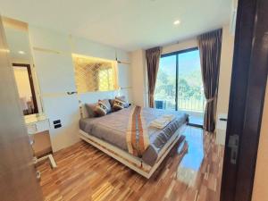 - une chambre avec un grand lit et une grande fenêtre dans l'établissement Doi Sutep Hill, à Chiang Mai