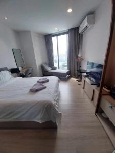 una camera d'albergo con un grande letto e un divano di EDGE Central Pattaya a Centro di Pattaya