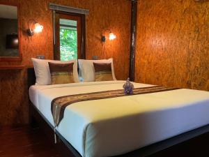 a bedroom with a large white bed in a room at Siam Lanta Resort - SHA Extra Plus in Ko Lanta