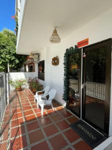 una casa con patio y 2 sillas blancas en Casa Inés Tolú en Tolú