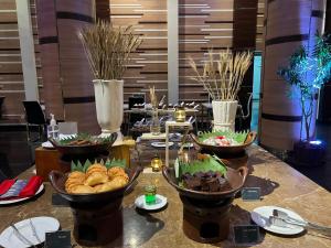 une table avec plusieurs bols de nourriture dans l'établissement Syariah Hotel Sentul, à Bogor