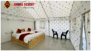 山姆Aroma Desert Safari Camp的一间卧室，里面有一张床和两把椅子