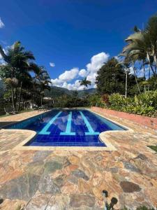 a swimming pool with blue tiles on the ground at Charming villa near to Medellín Metro and malls in Copacabana