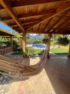 a hammock on a patio under a wooden roof at Charming villa near to Medellín Metro and malls in Copacabana