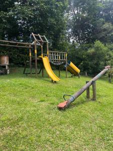 a playground with a yellow slide in the grass at Charming villa near to Medellín Metro and malls in Copacabana