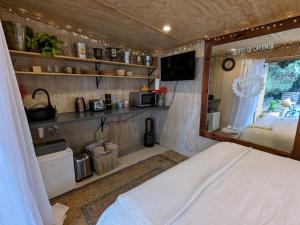 a bedroom with a bed and a kitchen in a room at Piccola Casa Fiorita in Mount Maunganui
