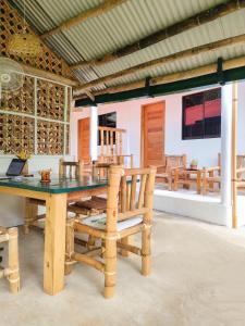 a dining room with a table and wooden chairs at Rose Apartments in Anda