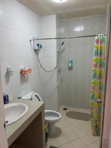 e bagno con doccia, servizi igienici e lavandino. di Petunya Phuket Guest House a Ban Huai Luk (1)