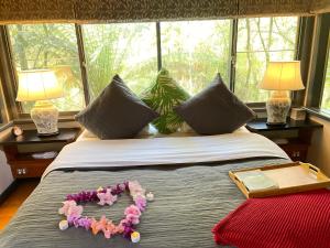 a bed with flowers on it with a window at Woodlands rainforest retreat in Narbethong
