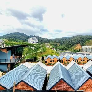 a group of roofs of houses with mountains in the background at Campod Resort @ Cameron Highlands in Cameron Highlands
