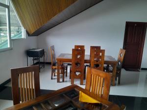 una sala da pranzo con tavolo e sedie in legno di Creek View Inn a Nuwara Eliya