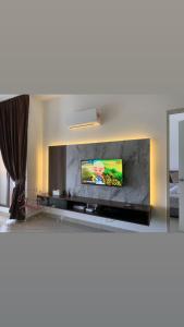 a living room with a flat screen tv on a wall at SuteraMuslimHomestay Bali Residence Melaka in Melaka