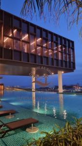 a building with a swimming pool at night at SuteraMuslimOnlyHomestay Bali Residence Melaka in Melaka