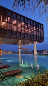 a building with a swimming pool at night at SuteraMuslimHomestay Bali Residence Melaka in Melaka