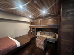 仙台市にあるHotel 螢月ｰhozukiｰ Adult Onlyの二段ベッド2台とベンチが備わる客室です。