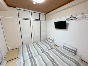 a bedroom with a bed and a tv in it at 江元浅草 in Tokyo