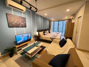 a living room with a bed and a tv in it at VitaminSEA2 Seaview 6PAX Studio Netflix A-9-16 in Kampung Saberang Balok