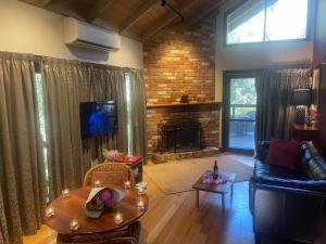 a living room with a couch and a fireplace at Woodlands rainforest retreat in Narbethong