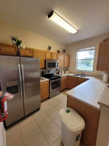 a kitchen with a stainless steel refrigerator and a trash can at Townhouse in Regal Palms Resort, Amenities, Pool & lazy river, Near Disney, Orlando in Davenport