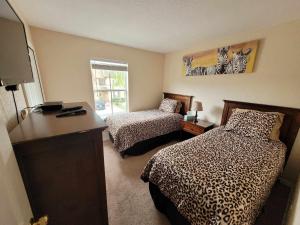 a hotel room with two beds and a television at Townhouse in Regal Palms Resort, Amenities, Pool & lazy river, Near Disney, Orlando in Davenport