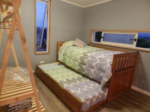 een kleine slaapkamer met een bed en een ladder bij Cabañas Piedra Negra, Los Molles in La Ligua