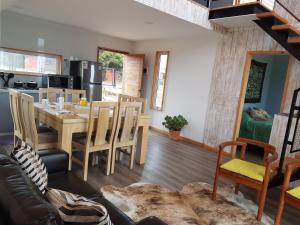 een keuken en een woonkamer met een tafel en stoelen bij Cabañas Piedra Negra, Los Molles in La Ligua