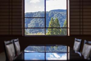 a window in a room with a view of a mountain at KAMENOI HOTEL Tazawako in Senboku