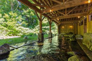 una casa con un estanque koi en el patio en KAMENOI HOTEL Tazawako, en Senboku