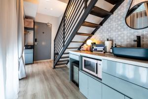 una cucina con armadi blu e una scala di Heritage Collection on Arab - Mobile App Check-In a Singapore